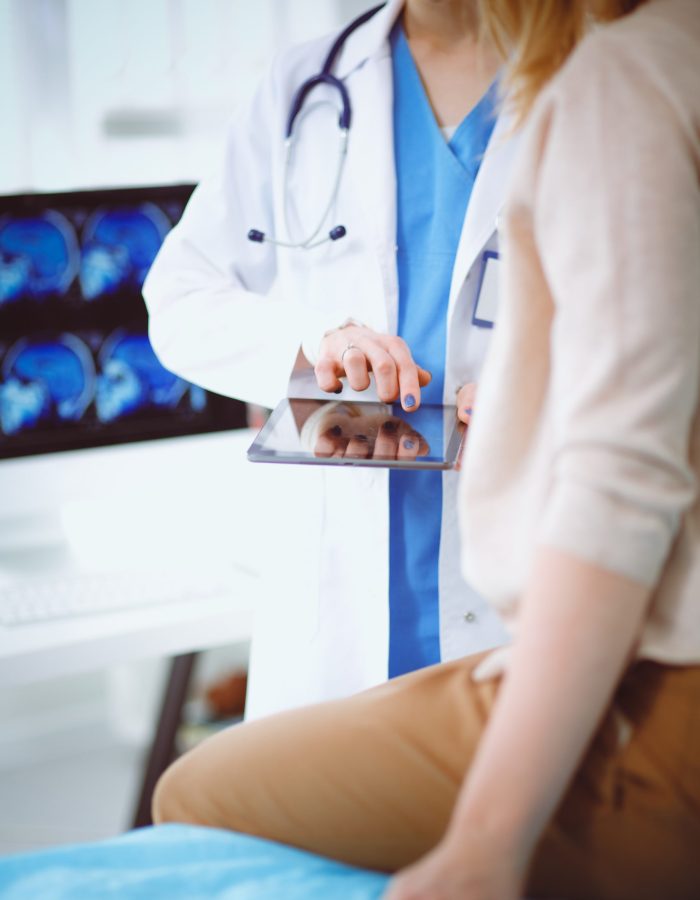 Doctor and patient discussing something while sitting at the table . Medicine and health care concept. Doctor and patient.